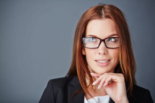 Pensive young businesswoman in eyeglasses