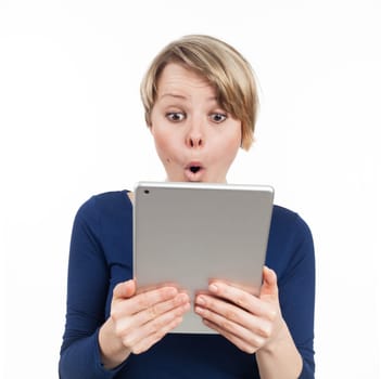 Young woman holding an electronic tablet and being astonished, isolated on white