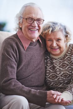 Happy elderly couple looking at camera and laughing