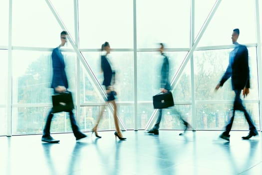 Busy managers moving inside office building