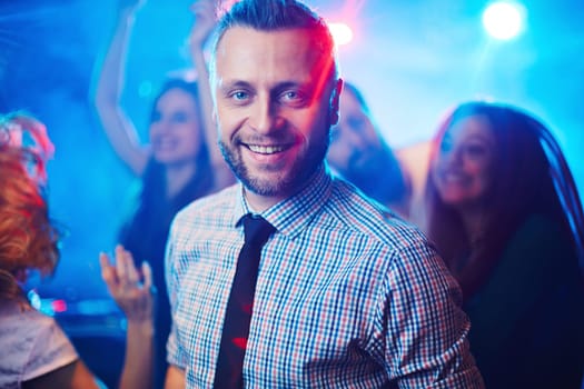 Happy and elegant man looking at camera at party