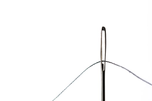 Sewing Needle Close Up With Black Thread through the eye.