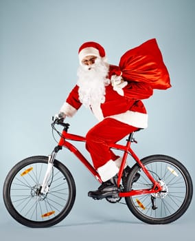 Santa Claus with red sack riding bicycle