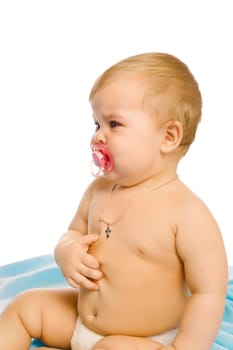 upset baby in diapers on a blue coverlet. Studio