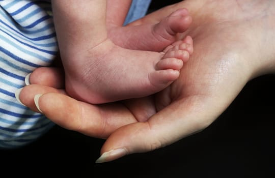 Baby's foot in mother's hand