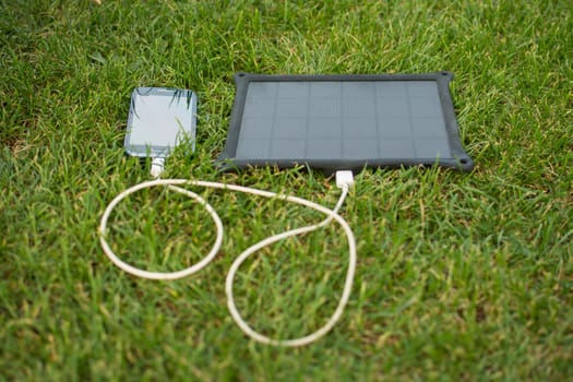 Use of renewable energy - Mobile Phone Chargers on grass in nature with Sun
