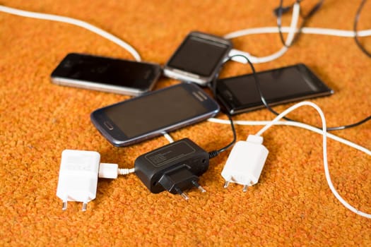 Phone Chargers on the orange carpet floor