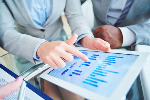 Employees with touchpad discussing marketing fluctuations