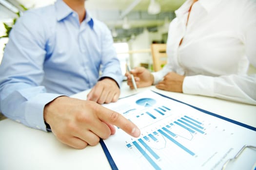 Businessman pointing at chart during discussion of document