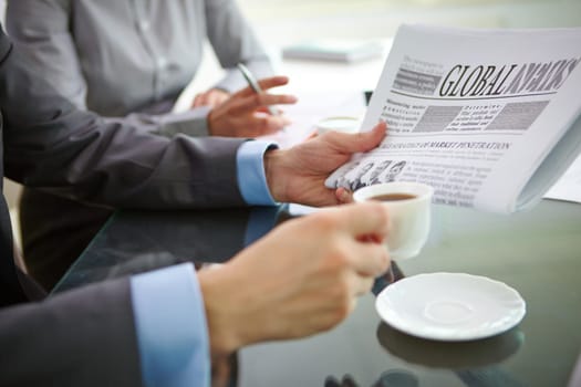 Businessman having morning coffee while reading latest news