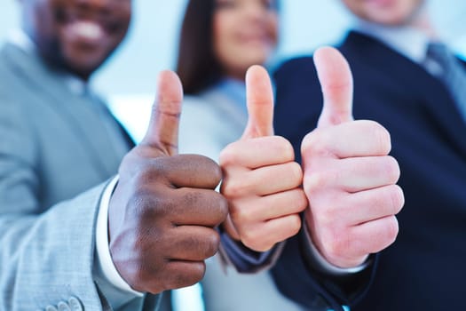 Thumb up gesture shown by group of employees