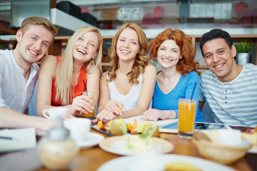 Cheerful friends relaxing in cafe between studies