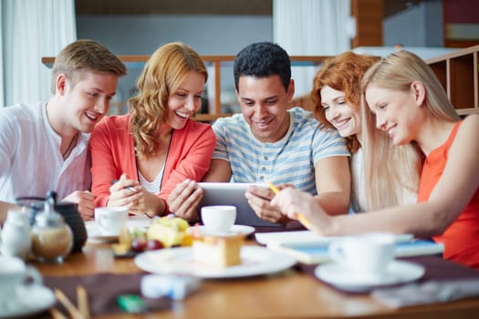 Modern teens with touchpad networking in cafe