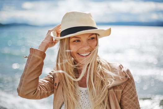 Blond girl in hat spending leisure by the seaside