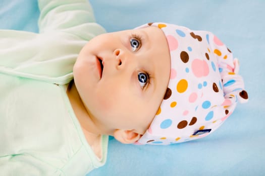 Charming baby girl in a hat. Studio