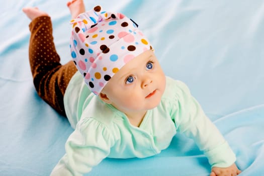 Charming baby girl in a hat. Studio