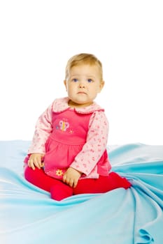 Little girl baby in a dress sitting on the floor
