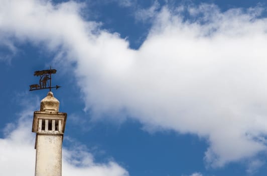 Weather-vane with the shape of a pig with swineherd under oak tree over a chimney