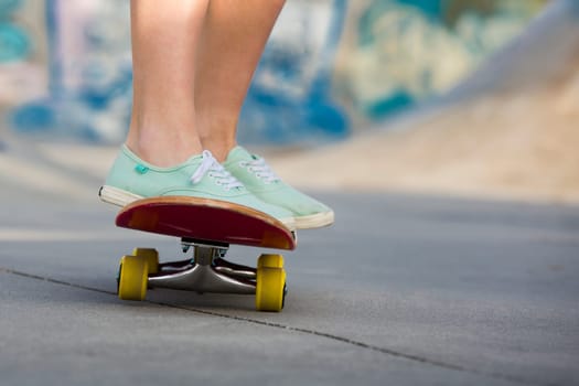 Detail of a young woman feet riding a skateboard