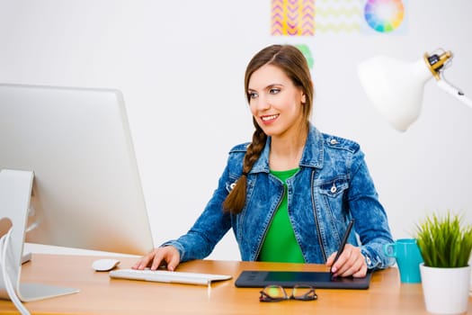 Woman working at desk In a creative office, using a computer