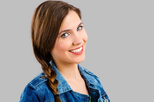 Portrait of a beautiful woman smiling over a grey background