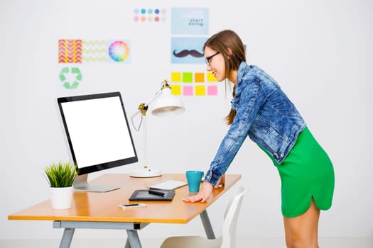 Woman working at desk In a creative office, using a computer