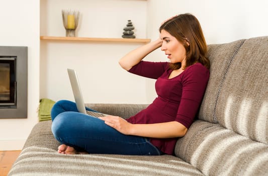 Beautiful woman working from the confort of home with her laptop