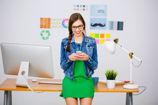 Woman working at desk In a creative office, using a computer