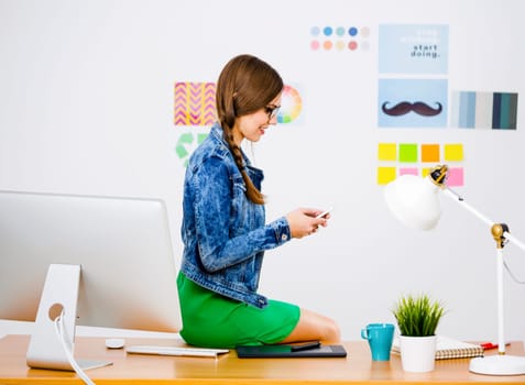 Woman working at desk In a creative office, using a computer