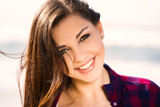 Beautiful and happy teen at the beach enjoying the summer
