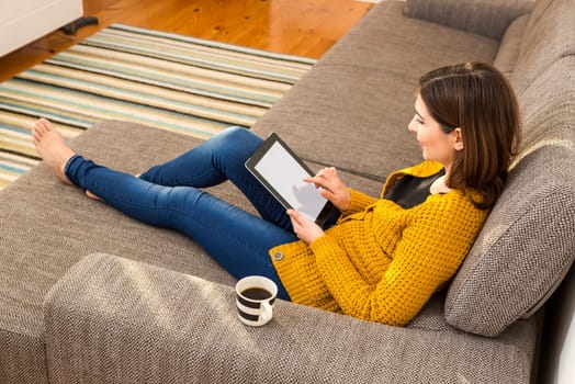 Beautiful young woman working with a tablet at home