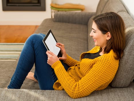 Beautiful young woman working with a tablet at home
