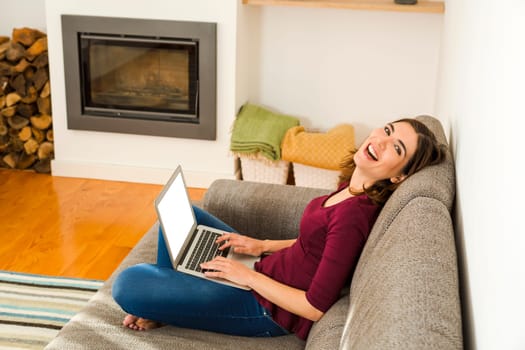 Beautiful woman working from the confort of home with her laptop