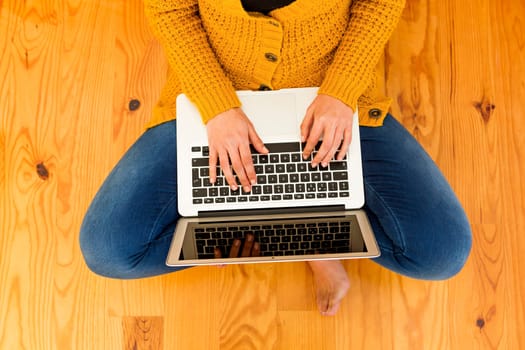 Beautiful woman sitting on the floor working with a tablet