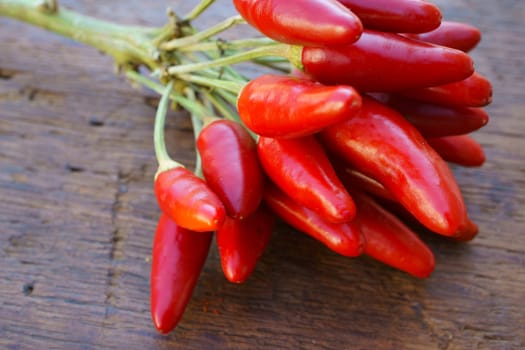 Bunch of fresh chillies on rustic wooden table