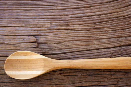 Wooden cooking spoon on rustic wooden background