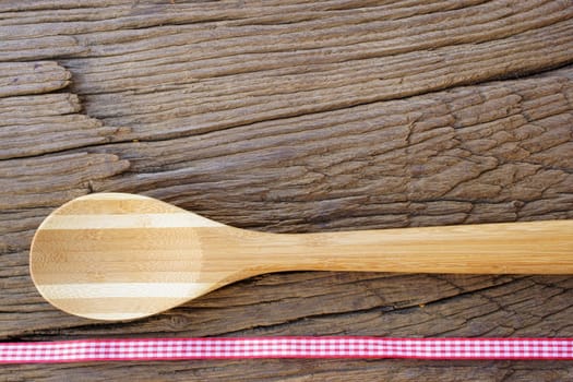 Wooden cooking spoon on rustic wooden background