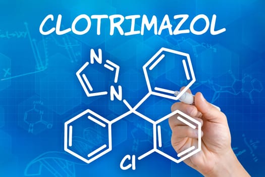 Hand with pen draws chemical structural formula of clotrimazole