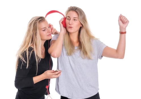 Two blonde women listen to music together through a headphone