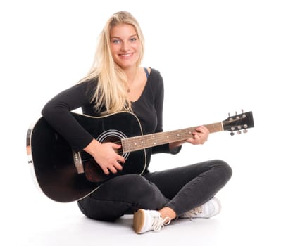 Pretty blonde girl sits in the tailor's seat and plays guitar