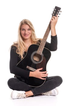 Pretty blonde girl sits in the tailor's seat and plays guitar