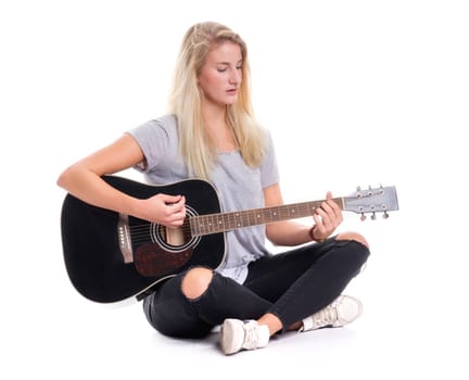 Young girl sits in the tailor's seat and plays guitar