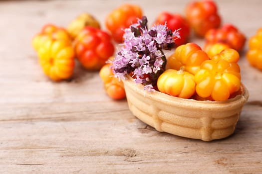 Cloudberry tart decorated with wild marjoram. Sweet baked dessert with fresh wild cloudberries on a wooden table.