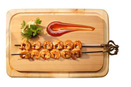 Grilled shrimps on a elegant skewers decorated with greens and sauce. Prawn kebab. Healthy seafood dinner.