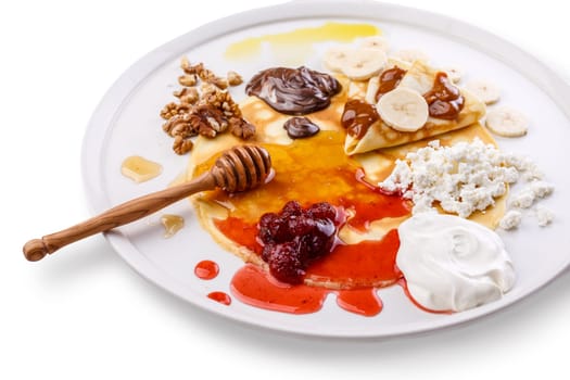 Crepes on a dish with various sweet toppings. Russian blini dessert. Sweet food