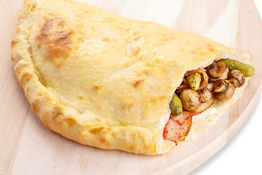 Neat, tasty and elegant closed pizza (calzone) stuffed with bacon,mushrooms and gherkins