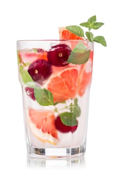 Grapefruit cherry mojito cocktail in faceted highball. Refreshing summer drink with rum,grapefruit and fresh mint