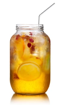 Glass jar of homemade spritzer (schorle) with carbonated apple juice served with frozen fruit wheels, ice cubes and wild cranberry