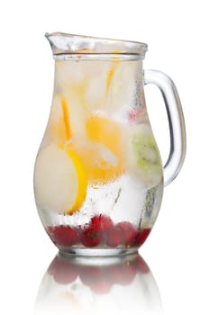 Glass pitcher of homemade detox water enriched with cherries and frozen fruit wedges. Misted jug full of cold water with popsicles. Clean eating