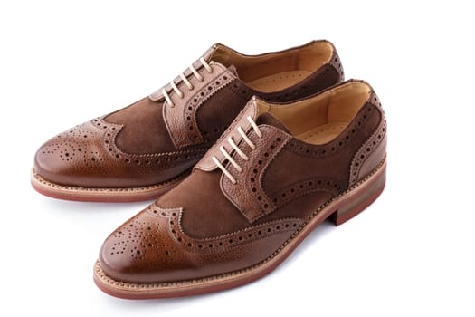 Unworn, laced pair of handcrafted shiny, two tone men brogues (also known as derbys, gibsons or wingtips) on durable welted red brick rubber sole. The upper is stunning combination of brown calf with brown suede. Isolated on white background with soft diffused drop shadow.
